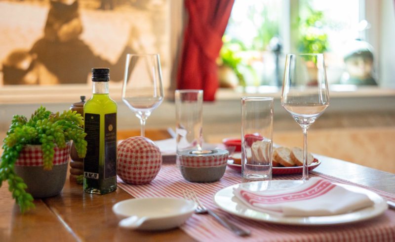 Gedeckter Tisch mit Weingläsern, frischem Olivenöl und Brot in der Seewirtschaft