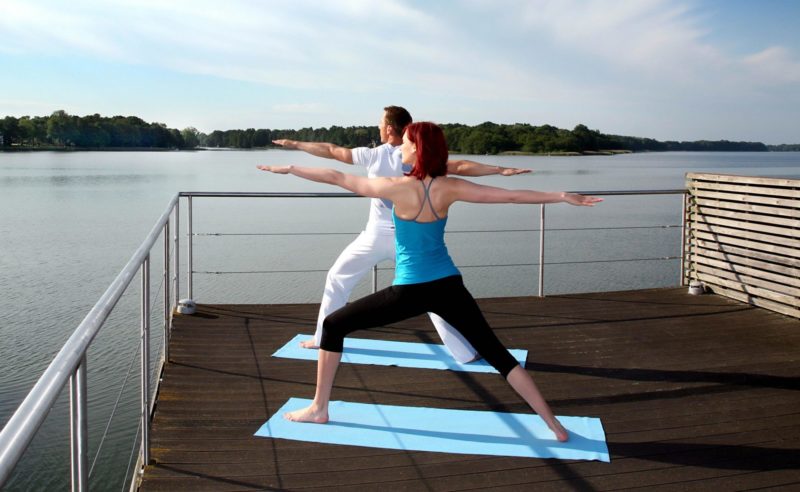 Paar beim Yoga auf der Dachterasse des Resorts Mark Brandenburg