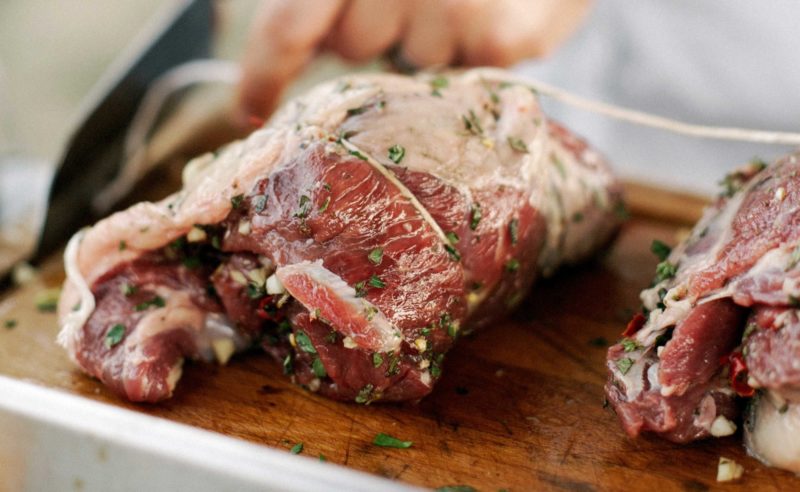 Rohes Fleisch mit Kräutern übersäht vor der Zubereitung durch den Koch