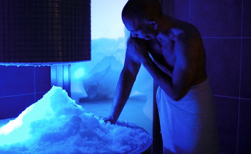 Mann kühlt sich nach Saunabesuch im Eisraum ab