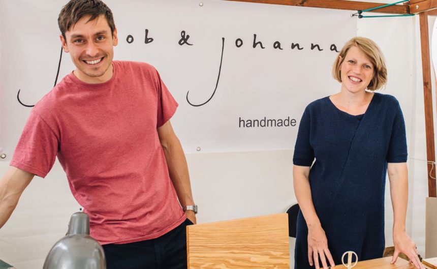 Junger Mann und junge Frau an einen Handrade Stand zum Verkauf