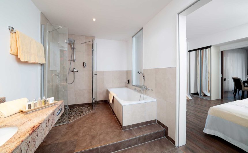 Großes Badezimmer mit Dusche und Badewanne in der Suite des Hotel Neuruppin