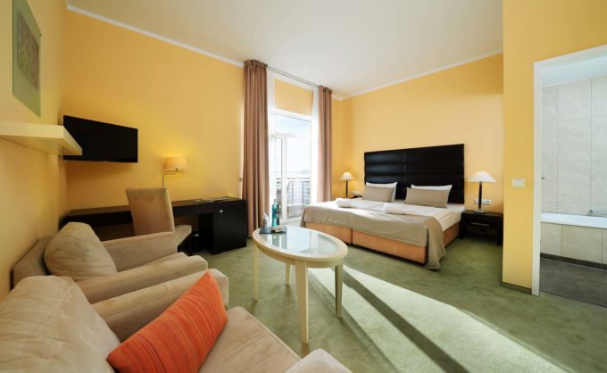 Wohn-und Schlafbereich in einem Zimmer des Hotels Resort Mark Brandenburg in Neuruppin