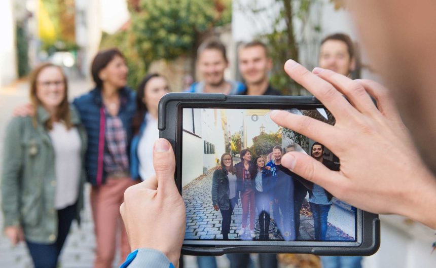 Gruppe wir mit dem iPad fotografiert vor dem Tagungshotel Brandenburg