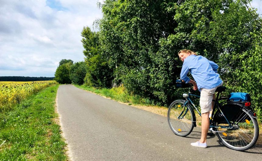 Frau macht eine Pause auf ihrem Fahrrad während einer Tour durch die Region Neuruppin