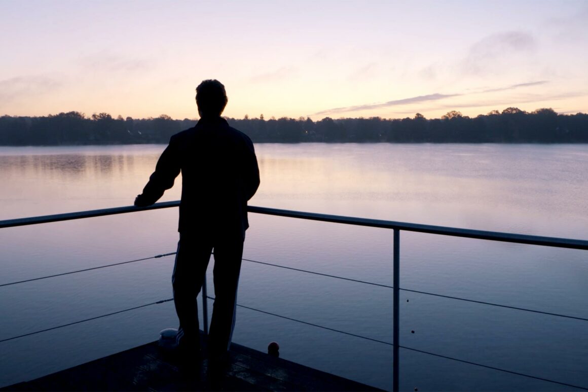 Person genießt die Aussicht über den Ruppiner See im Abendrot