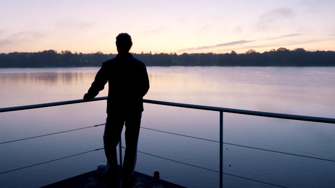 Person genießt die Aussicht über den Ruppiner See im Abendrot