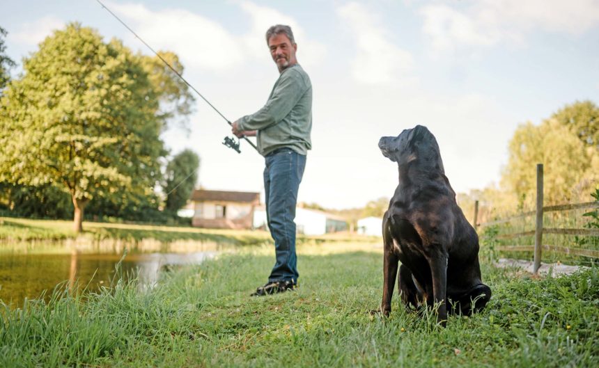 Partner Fischzucht beim Angeln mit seinem Hund