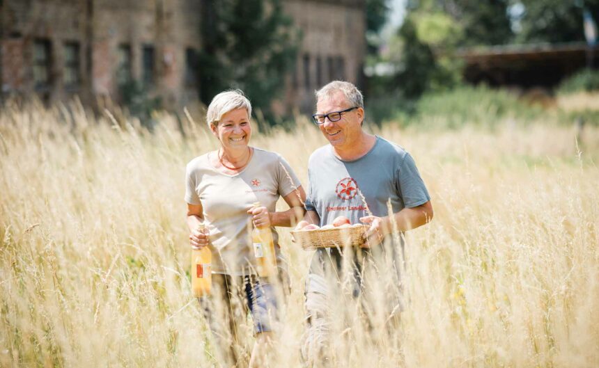 Mann und Frau Linum laufen über ein Feld und lächeln dabei