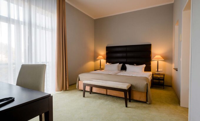 Komfortables Doppelbett in lichtdurchfluteter Junior-Suite mit Teppichboden.