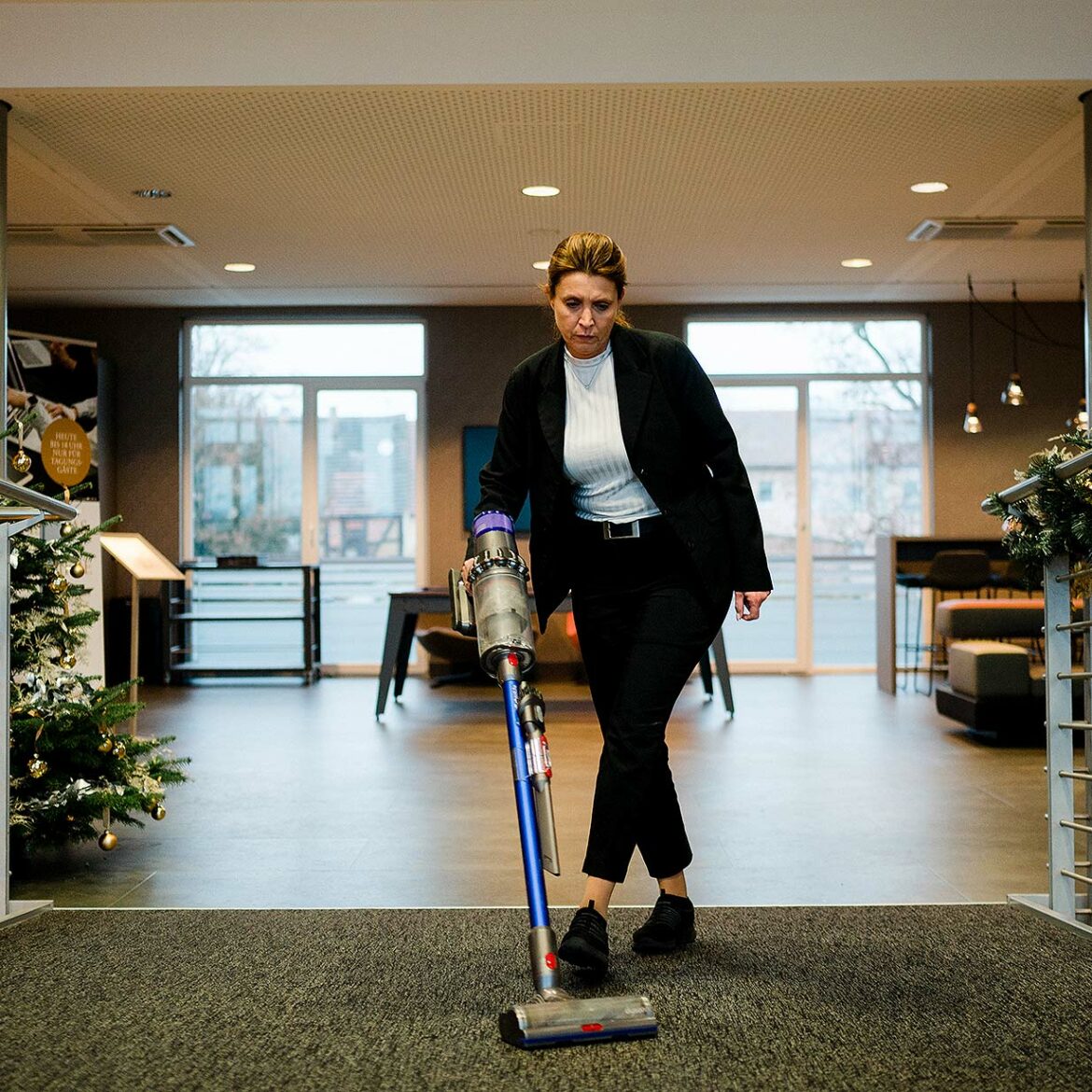 Eine Frau staubsaugt in der Lobby des Resort Mark Brandenburg.