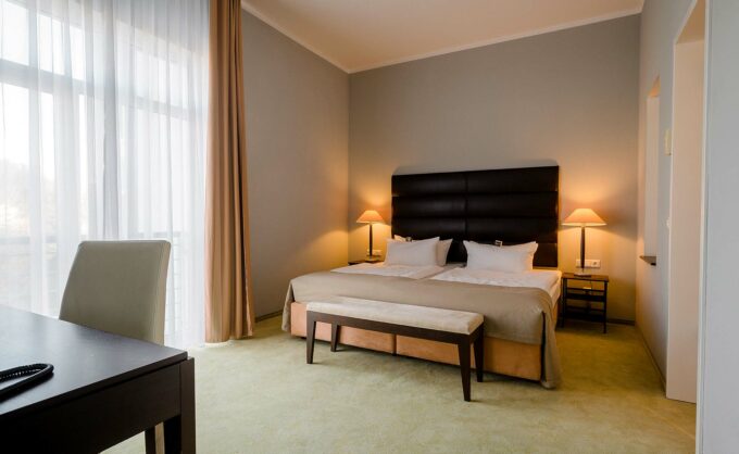 Komfortables Doppelbett in lichtdurchfluteter Junior-Suite mit Teppichboden.